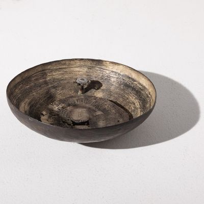 un bol noir posé sur une table blanche