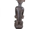 an image of a statue of a person sitting on top of a wooden base