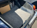 le coffre d'une voiture dans lequel se trouve une boîte en carton