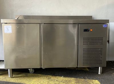 un réfrigérateur en acier inoxydable posé au milieu d'un parking
