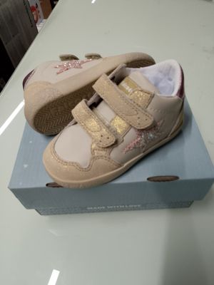 une boîte sur laquelle est posée une paire de chaussures de bébé