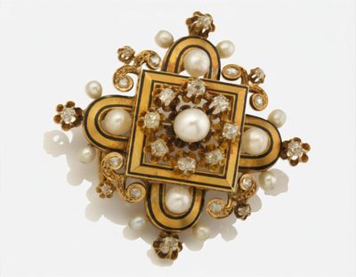 une image représentant une broche ornée de perles et d'or sur fond blanc