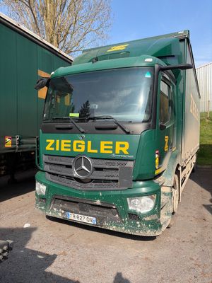 un camion vert garé à côté d'une remorque verte