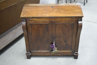 une armoire en bois sur laquelle se trouve une clé, dans une pièce
