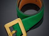 un gros plan sur une ceinture verte ornée d'une boucle dorée
