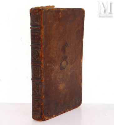 an old book sitting on top of a table next to a white wall