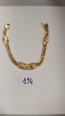 deux colliers en or exposés dans une boîte blanche avec une étiquette de prix