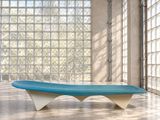 un banc bleu et blanc dans une pièce dotée de grandes fenêtres