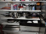 de nombreuses casseroles et poêles sur les étagères de la cuisine