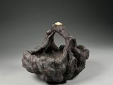 a close up of a sculpture of a person sitting on a rock