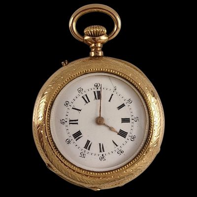 a gold pocket watch with roman numerals on the face