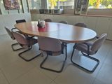 a table with chairs and a vase on it in a room
