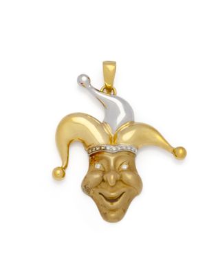 un gros plan sur un pendentif en forme de tête de bouffon en or jaune et or blanc