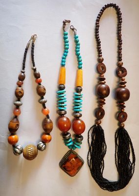 trois colliers et un collier orné de perles sur un fond blanc