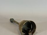 an image of a small brass bell on a white surface