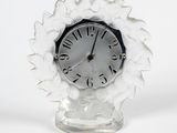 une horloge blanche posée sur un socle en verre