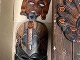 three wooden masks hanging on the wall next to each other