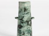 a green vase that is sitting on a white surface