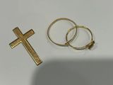 deux bagues et une croix en or posées sur une table