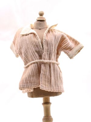 un mannequin vêtu d'une robe, posé sur un socle en bois