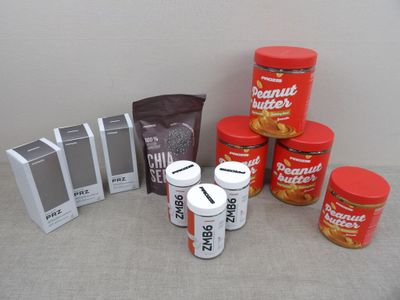 Plusieurs pots de beurre de cacahuète sont posés sur une table, à côté d'une boîte de beurre de cacahuète.