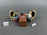 two figurines of a man and a woman sitting at a table