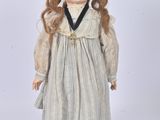 an old doll with long hair wearing a dress and shoes