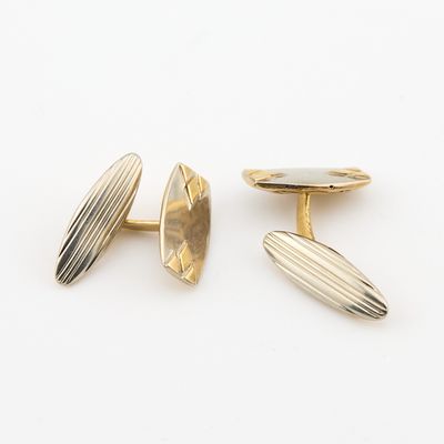 une paire de boutons de manchette en or et en argent sur fond blanc