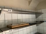 a metal shelf with a box on it in a kitchen
