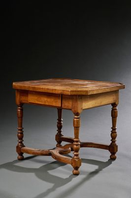 une vieille table en bois avec des pieds tournés et un plateau en bois
