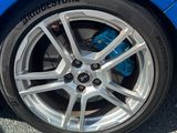 un gros plan sur un pneu d'une voiture de sport bleue