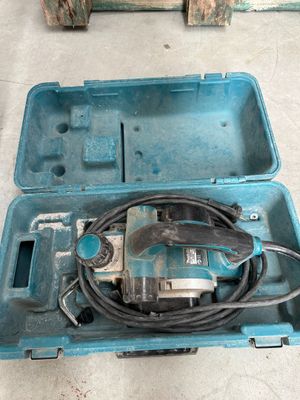 une mallette bleue contenant une perceuse et un cordon d'alimentation