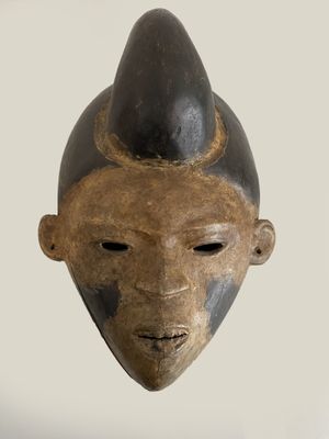 an image of a wooden mask with a black hat on it