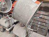 a cement mixer and a fan sitting on the ground
