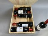 three bottles of wine in a wooden box next to a bottle of wine