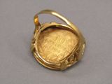 une image représentant une bague en or renfermant une pièce de monnaie