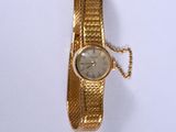 l'image d'une montre-bracelet en or entourée d'une chaîne