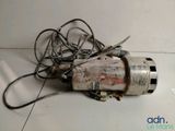 une petite perceuse électrique posée par terre à côté d'un enchevêtrement de fils
