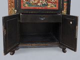 a black cabinet with a painting on the door