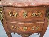 a small chest of drawers with a marble top