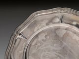 a silver plate with a design on it on a table