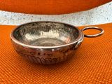 silver plated bowl with handle on orange cloth