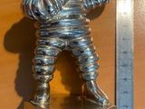une figurine en argent représentant un homme tenant une raquette de tennis posée sur une pile de sous-verres