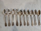 six cuillères en argent alignées en rang sur une table
