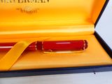 un stylo-plume rouge dans une boîte jaune ornée d'un ruban jaune