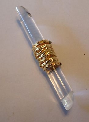 un tube en verre surmonté d'un anneau en or
