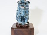 statue of a blue dog on a wooden base on a white background