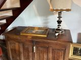 a table with a lamp on it next to a stair case