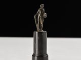 statue d'un homme tenant un ballon de basket sur un socle noir
