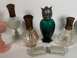 Plusieurs vases en verre sont alignés sur une surface blanche